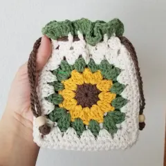 Our popular crochet sunflower pouch, designed with a classic granny square pattern. This drawstring bag is perfect for storing small treasures like coins, jewelry, or earphones, and is handmade with soft, washable yarn.