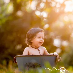 Pure happiness in a tub. The beautiful bokeh and warm sunlight in this outdoor bath session create a dreamy and heartwarming image.