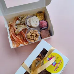 This is my 'Moose's Chakhna Box', a savoury selection perfect for any occasion. It features single-ingredient dehydrated anchovies, chicken jerky, house-made chicken salami, and crunchy biscuits.