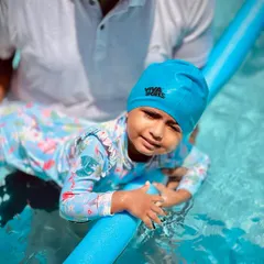 Using tools like pool noodles helps toddlers feel secure while learning to float. Our coach is gently guiding this young swimmer to find her balance and comfort in the water.