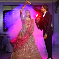 A couple shares their first dance, surrounded by theatrical smoke and colorful lights. I work to create dramatic, memorable images from the most important parts of your reception.