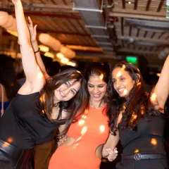 A trio of friends dancing and smiling at VIBE CHECK Friday. This is what a great night out looks like.