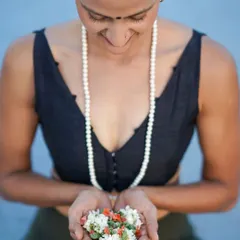 A moment of peace, holding flowers as an offering. This image captures the gentle, devotional side of my practice and my connection to the traditions of yoga.