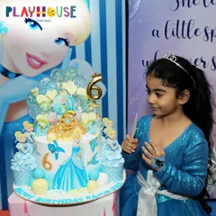 The birthday girl, dressed as Cinderella, looks at her magnificent themed cake, ready to make a wish. These are the magical moments I love to create.