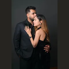 An elegant and intimate studio portrait. The all-black attire and simple background create a sophisticated and modern look for this couple's photoshoot.