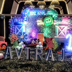 A dazzling Cocomelon party with a sequin backdrop. The combination of colorful lights, character cutouts, and a shimmering background creates a truly spectacular farm-themed celebration.