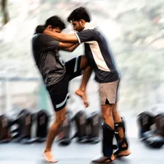 Clinch work is where Muay Thai fighters dominate. Here, two students drill for position, practicing knee strikes in close quarters.