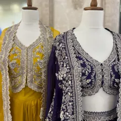 A duo of modern lehenga sets with intricately embroidered jackets. The yellow and deep purple outfits offer a contemporary yet regal look for any celebration.