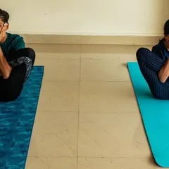 Two young yoginis exploring a playful pose. When children start yoga at an early age, they develop tools for life, helping them stay less stressed, happier, and more content.
