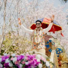 A groom's spectacular entry on a decorated chariot. This fun and regal arrival, set against a backdrop of blooming trees, makes for an incredible start to the wedding festivities.
