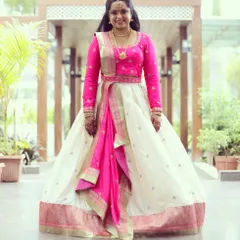 Deepika looks stunning in this custom-designed half saree. I paired a simple, elegant off-white skirt with a vibrant pink long-sleeved blouse and a matching draped dupatta.