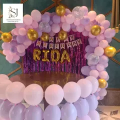A beautiful pink and purple balloon arch with a shimmer backdrop, perfect for an at-home birthday party. This setup for Rida created a glamorous and fun atmosphere for her celebration.
