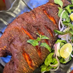 This is our legendary Tandoori Fried Fish, a dish we are truly famous for. We use fresh Tilapia, marinate it in our secret blend of tandoori spices, and fry it to crispy perfection. It's a must-try when you visit us.