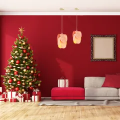 A bold red living room is made even more festive with a pair of modern, petal-like pendants. This lighting choice complements the Christmas decor and creates a vibrant, celebratory atmosphere.
