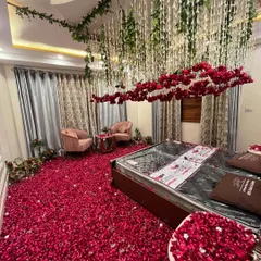 I can transform a room with more than just a bed canopy. Here, I created a floating cloud of red roses and hanging floral strings over the bed, with a dense carpet of petals on the floor for a truly immersive and luxurious feel.