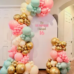 A trendy "The Summer I turned 16" birthday theme. This setup features a modern arched backdrop and an organic balloon garland in a beautiful pastel pink, mint, and gold color scheme.