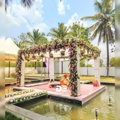 A different perspective of the serene floating mandap, showcasing the lush floral arrangements on the pillars and the walkway. This setup at a Bengaluru wedding venue was designed to feel both grand and intimately connected with nature.