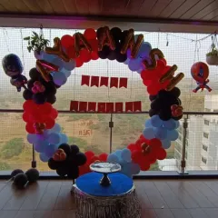This Spiderman-themed ring decoration was set up on a balcony, making great use of the space. The circular frame is perfect for creating a focal point for cake cutting, even in a compact area.