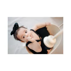 A playful look from a baby girl in a basket. I love this unique angle, which captures her curiosity and adorable expression.