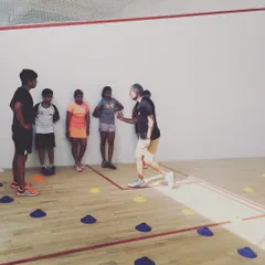 A coach explains the nuances of a footwork drill before the session begins. We ensure every player understands the purpose behind each exercise to maximize their learning and performance.