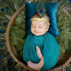 For my littlest clients, I offer unique traditional themes like this adorable Kaanha setup. This newborn photoshoot features a peacock feather headpiece and a serene, sleepy pose.