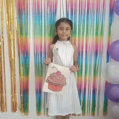 The birthday girl, Uma, proudly showing off the cupcake-themed tote bag she painted at her party. Every child gets to take their masterpiece home as a special party favor.