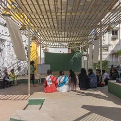 An educational session in progress at Basera. The space was designed to be a versatile platform, accommodating everything from vocational training to informal gatherings, all sheltered under a light-diffusing bamboo canopy.