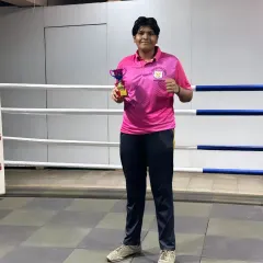 Victory in the ring. One of our boxers proudly displays her trophy after a win at the "PINK POWER" open invitational tournament.