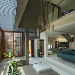 A view from the family room overlooking the double-height internal courtyard in "The Mantle" house. This visual connection across floors ensures the home feels open and integrated with its green core.
