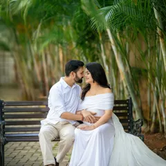 An intimate moment between an expecting couple on a park bench. The flowing white dress, which I provide, adds a touch of elegance and romance to the maternity portrait.