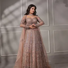 A full-length view of this gorgeous engagement bride. The soft, shimmering lehenga is perfectly complemented by a glamorous makeup look with defined eyes and flowing hair, creating a truly elegant silhouette.