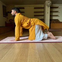 This is the starting position for Marjaryasana-Bitilasana (Cat-Cow Pose). I teach students to synchronize breath with movement to warm up the spine and relieve tension in the back and neck.
