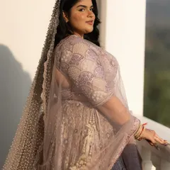 A beautiful close-up portrait of the bride, Rhea, bathed in the golden hour light on a balcony. Her soft smile and the delicate veil create a serene and lovely image.