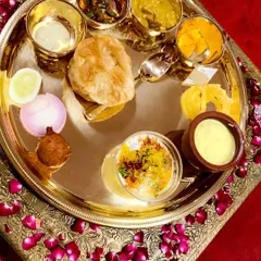 A feast for the eyes and the palate. This is a look at a complete Royal Thali, featuring a curated selection of premium North Indian vegetarian dishes like rich dals, paneer, fluffy puris, and traditional sweets.