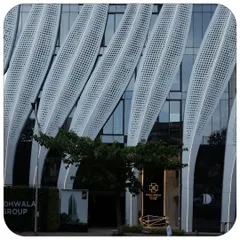 The entrance of the ID Origins building, where the calligraphic strokes touch the ground. This detail shows how the grand architectural gesture is integrated at a human scale, creating a welcoming urban lobby.