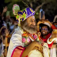 A candid moment of Gurudev during the Maha Shivratri celebrations. His presence, adorned in traditional attire, brings a unique blend of wisdom and playfulness to the grand festival.