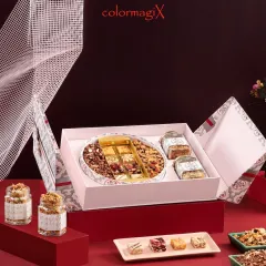A unique folding Diwali gift box in a subtle pink and grey design. The box opens to reveal a central platter of mixed dry fruits and compartments for other festive treats.