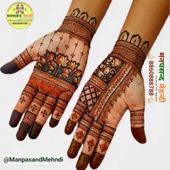 A beautiful example of modern floral mehndi. This design features delicate lotus flowers on a light background, with contrasting patterns on the wrist and fingers.