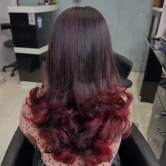For clients who want a bold yet elegant change, I love creating looks like this plum red ombre. The color melts from a natural dark base into vibrant red ends, styled with soft curls to show off the color gradient. This is a great way to express your personality.