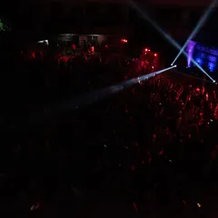 A wide shot of the massive crowd at the New Horizon College fest. The combination of stage lights and phone flashlights creates a stunning visual.