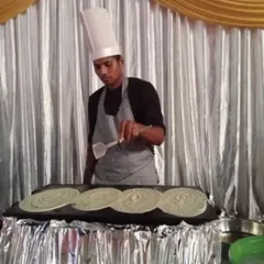 My interactive live counters are always a hit with guests. Here you can see one of my chefs preparing fresh, hot dosas on a large tawa, providing both a delicious meal and an engaging experience for everyone at the party.