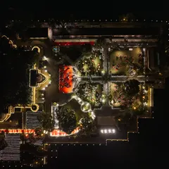 An aerial drone view of the event layout at Jagmandir Island Palace. My planning process involves meticulous space management to ensure a seamless flow for guests, from the dining areas to the central performance stage, all lit to create a magical ambiance.