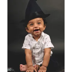 A happy wizard in the making! This baby's bright smile and playful pose make for a heartwarming and memorable themed portrait.