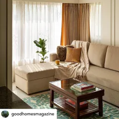 A close-up of the L-shaped sofa, a perfect spot for relaxation. The combination of sheer and heavy curtains allows for versatile light control while adding to the room's soft, layered look.