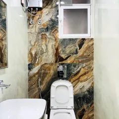 The accent wall in this bathroom uses a bold, earthy-toned tile that mimics natural stone, adding texture and a touch of drama to the space.