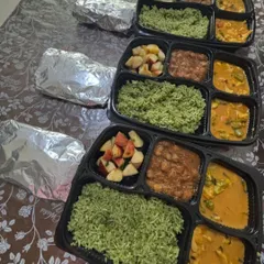 This healthy meal box features spinach rice, vegetables in a creamy tandoori sauce, and chole with pooris. It's a complete and nutritious option for office lunches or events.