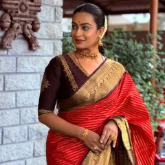 A timeless look featuring a deep brown blouse with delicate V-neck embroidery. This demonstrates how an elegant, well-fitted blouse can enhance the beauty of a classic silk saree.
