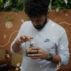 A guest puts the finishing touches on his terrarium, ensuring every plant and stone is perfectly placed. The process is one of focus, creativity, and connection with nature.