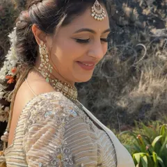 A side profile showing the soft eye makeup and the beautiful, traditional hairstyle adorned with fresh flowers.