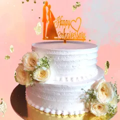 This two-tiered anniversary cake is a vision in white, adorned with delicate fresh roses. It’s a timeless and romantic design, perfect for celebrating years of love and partnership, baked fresh for your special day.